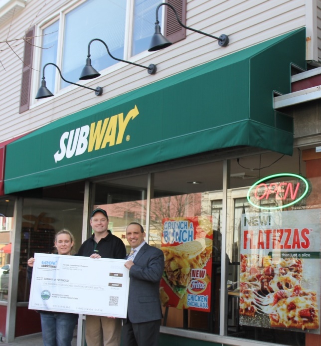 Freeholder Thomas A. Arnone (right) presents Subway of Freehold owners Jillian and Keith Harrington with a Façade Improvement Program check for $1,482 for exterior lighting at their restaurant on Tuesday, March 11, 2014 in Freehold, NJ.